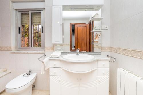 Un baño blanco con lavabo e inodoro. en BaruHaus VillaHermosa, en Villamañán