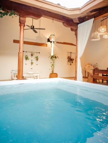 an indoor swimming pool with blue water in a house at Central Park Luxurious Historical Home With Pool in Granada