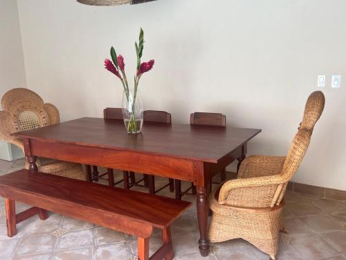 a wooden table with a vase with flowers in it at Central Park Luxurious Historical Home With Pool in Granada