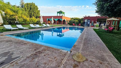 a swimming pool with lounge chairs next to a house at Tente berbère in Marrakech