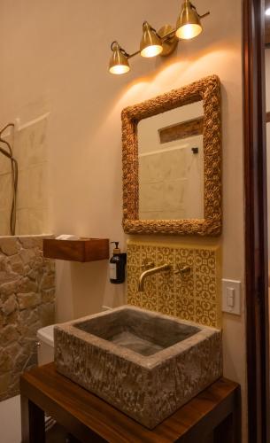 a bathroom with a stone sink and a mirror at Central Park Luxurious Historical Home With Pool in Granada