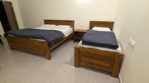 two twin beds sitting in a room with at Siri Serenity by Illika in Tarikere
