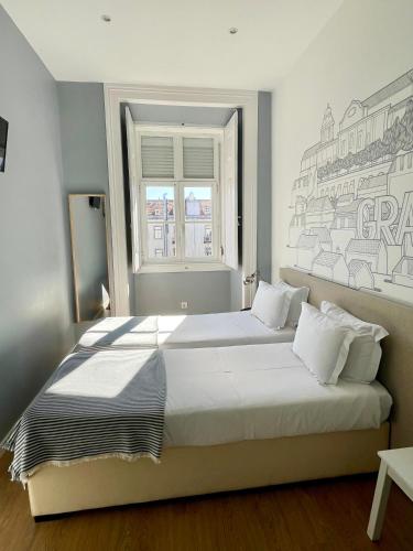 a bedroom with a large white bed with a window at Lisbon Check-In Guesthouse in Lisbon
