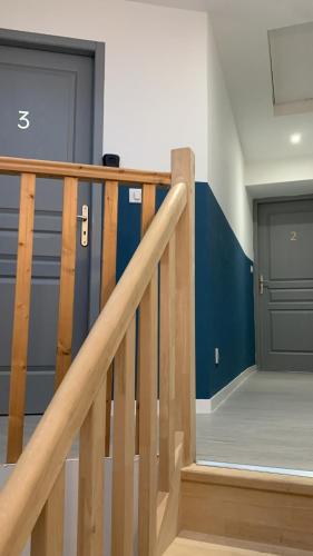 Un escalier en bois mène à un garage avec une porte. dans l'établissement Grande chambre privée au DUPLEX DU CLOITRE MOISSAC, à Moissac