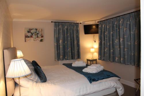 a bedroom with a bed and two lamps and a window at Shandon Farmhouse Bed and Breakfast in Drymen