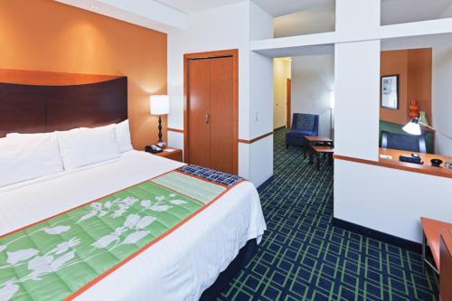 a hotel room with a large bed and a desk at Fairfield Inn & Suites Tulsa South Medical District in Tulsa