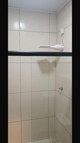 a bathroom with a shower with a white tiled wall at casa por temporada pontal da barra in Maceió