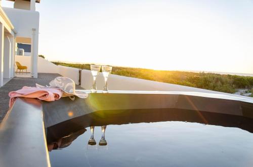 a boat sitting in the water with two wine glasses at Bella La Vita Beachfront Villa in Velddrif