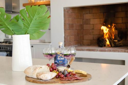 a table with two glasses of wine and a plate of food at Bella La Vita Beachfront Villa in Velddrif