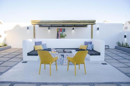 a patio with two chairs and a coffee table at Bella La Vita Beachfront Villa in Velddrif