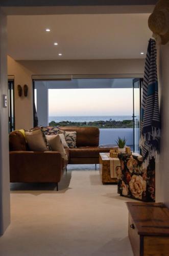 a living room with a couch and a large window at Bella La Vita Beachfront Villa in Velddrif