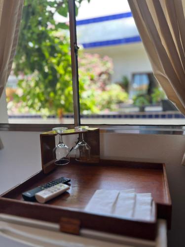 a remote control sitting on a table next to a window at Pousada Weiss Blau in Ilha Comprida