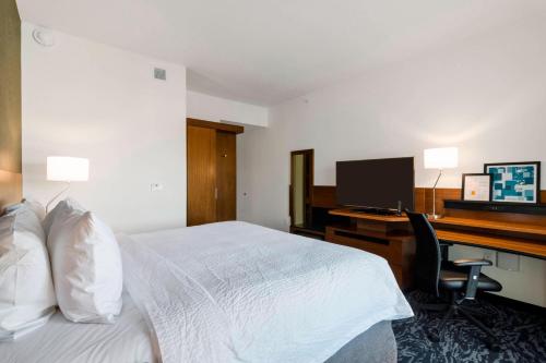 a hotel room with a bed and a desk with a computer at Fairfield Inn & Suites by Marriott St Petersburg North in St Petersburg