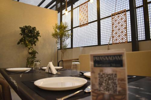 a table with plates and napkins on it in a restaurant at Arjun - A boutique hotel in Haridwār