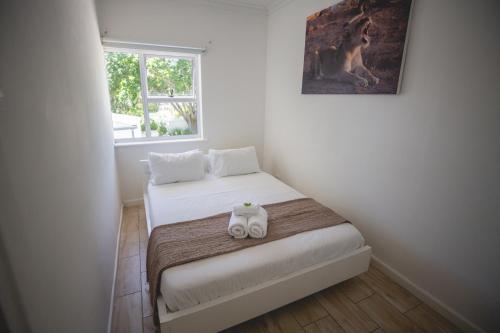 a bedroom with a bed with two towels on it at theLAB Luxury Backpackers in Franschhoek