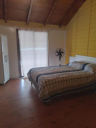een slaapkamer met een bed en een groot raam bij Cabaña El Banbi in La Coronilla