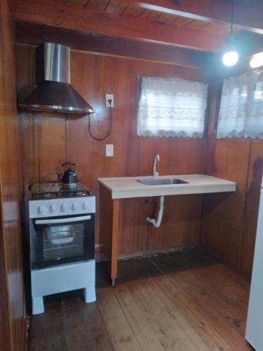 een kleine keuken met een spoelbak en een fornuis bij Cabaña El Banbi in La Coronilla