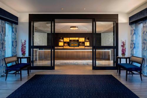 a lobby with two chairs and a glass door at Four Points by Sheraton Norwood Conference Center in Norwood