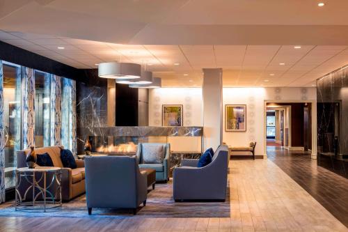 a lobby of a hotel with couches and chairs at Four Points by Sheraton Norwood Conference Center in Norwood