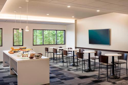 a conference room with tables and chairs and a flat screen tv at Four Points by Sheraton Norwood Conference Center in Norwood
