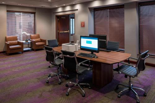 an office with a desk with a computer and chairs at Four Points by Sheraton Boston Logan Airport Revere in Revere