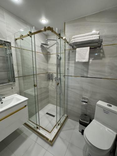 a bathroom with a shower and a toilet and a sink at Aram Hotel in Dushanbe