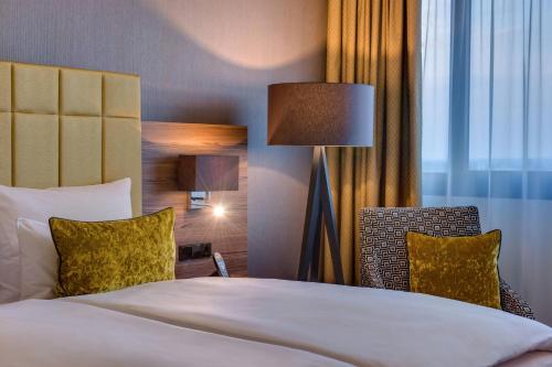 a hotel room with a bed and a lamp at Bonn Marriott Hotel in Bonn