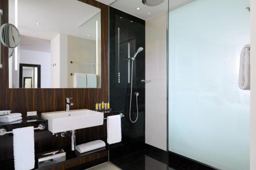 a bathroom with a sink and a shower at Bonn Marriott Hotel in Bonn