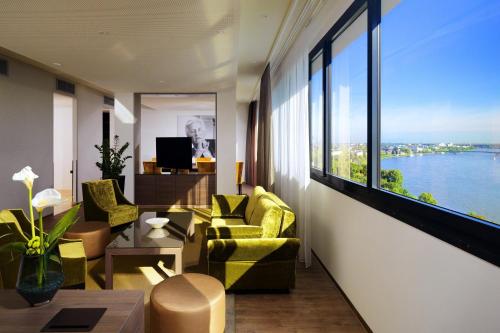 a living room with a view of the water at Bonn Marriott Hotel in Bonn