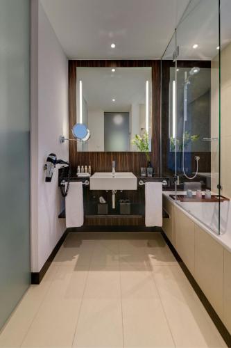 a bathroom with a sink and a large mirror at Bonn Marriott Hotel in Bonn
