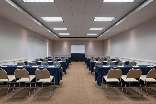 a large room with tables and chairs and a whiteboard at Four Points by Sheraton Monterrey Linda Vista in Monterrey
