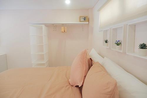 a bedroom with a bed with pillows on it at Ponder Bali Canggu in Canggu