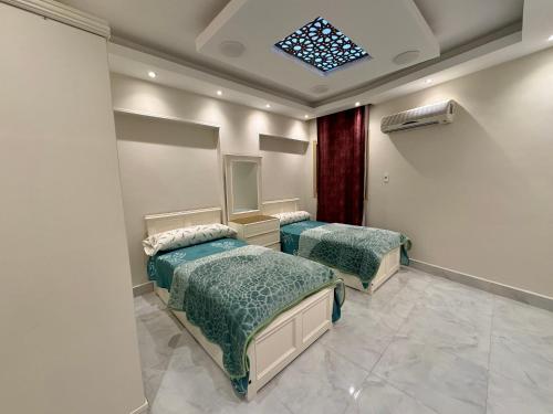 two beds in a room with a skylight at Dream Apartment in Cairo