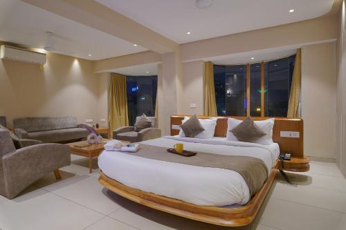 a bedroom with a large bed and a living room at Artilla Inn in Ahmedabad