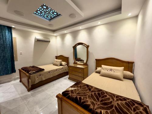 a bedroom with two beds and a mirror at Dream Apartment in Cairo