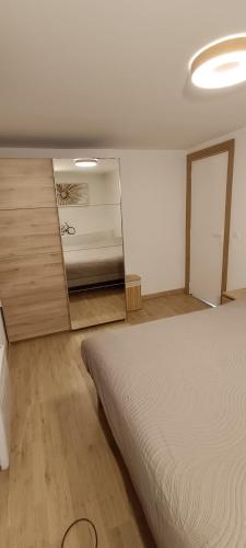 a bedroom with a bed and a cabinet in it at Maison Stival in Pontivy