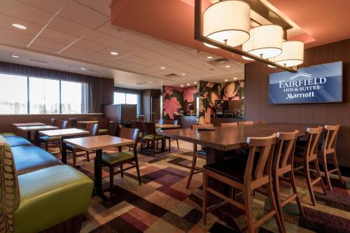 a restaurant with tables and chairs and a sign at Fairfield Inn & Suites by Marriott Atmore in Atmore