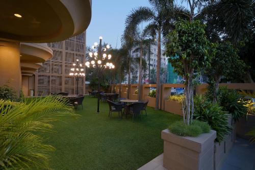 a courtyard with tables and chairs in a building at Artilla Inn in Ahmedabad