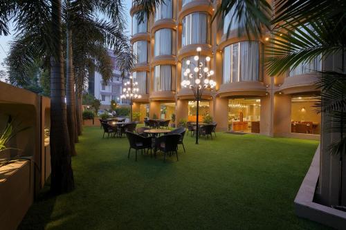 a restaurant with tables and chairs in a building at Artilla Inn in Ahmedabad