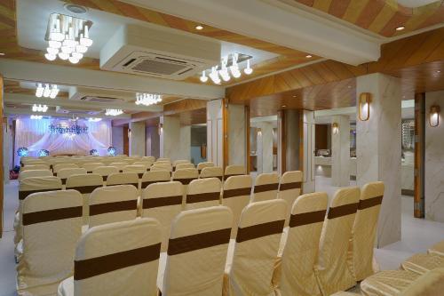 a conference room with rows of chairs and a stage at Artilla Inn in Ahmedabad