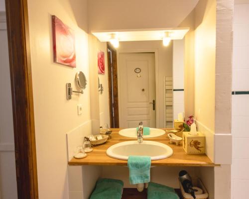 a bathroom with a sink and a mirror at Ferme de Marpalu in La Ferté-Saint-Cyr
