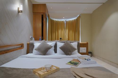 a bedroom with a white bed with a tray on it at Artilla Inn in Ahmedabad