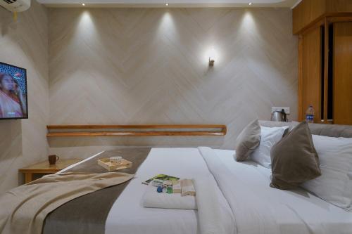 a bedroom with a white bed and a wall at Artilla Inn in Ahmedabad