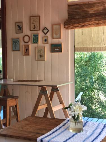 un tavolo con un vaso di fiori su un tavolo di la casa en el rio a Tigre