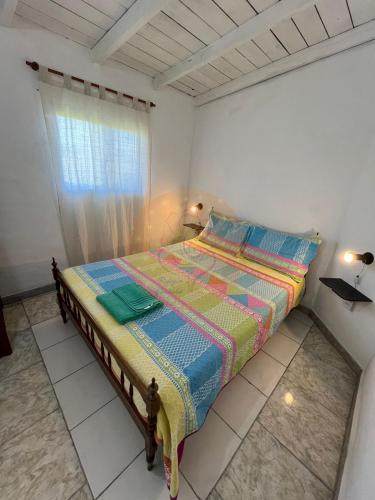 a bed in a white room with a window at Las Retamas in Chapadmalal