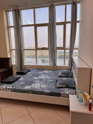 een bed in een kamer met een groot raam bij Stunning Corniche view in Ras al Khaimah