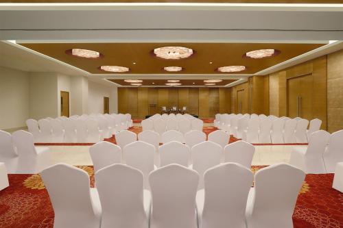 a conference room with white chairs and tables at Four Points by Sheraton Hotel and Serviced Apartments Pune in Pune