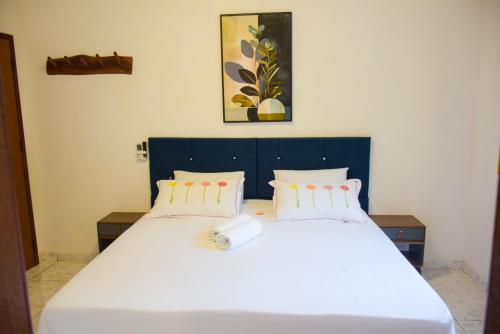 a bedroom with a large white bed with two pillows at Pousada Canto dos Pássaros in Lençóis