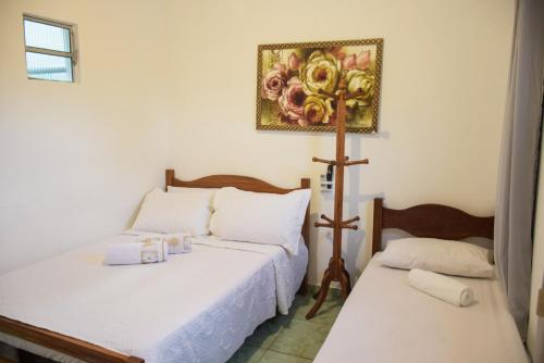 a bedroom with two beds and a picture on the wall at Pousada Canto dos Pássaros in Lençóis