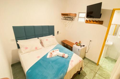 a small bedroom with a bed and a television at Pousada Canto dos Pássaros in Lençóis